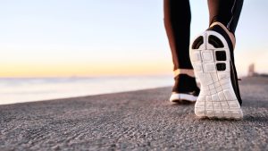 Ragazza che cammina sul marciapiede che costeggia il mare
